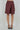 Women’s burgundy high-waisted Bermuda shorts with asymmetric wrap front, side buckle and tie detail.