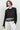 Women’s black long sleeve cropped top with macramé netting and tassel fringe hem.