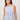 Women's blue striped peplum cami top featuring adjustable spaghetti straps, side drawstring ties, and a relaxed silhouette.