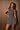 Women’s charcoal plaid sleeveless romper with smocked fitted bodice and flowy skirt-style shorts.