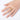 Gold ring on a finger against a white background