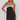 Woman wearing a black dress with a silver bow detail on a white background
