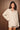 Women’s oversized cream and taupe striped button-down shirt with long sleeves and chest pocket.