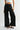 Women's black high-rise wide leg jeans featuring silver stud embellishments along the pockets and side seams with frayed raw hems.