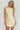 Woman wearing a light yellow dress with a plain background