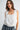 Women's white sleeveless embroidered blouse featuring eyelet lace trim, floral embroidery, scalloped details, and an adjustable tie neckline.