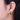 Close-up of an ear wearing a green gemstone hoop earring.
