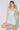 Woman wearing a light blue sequin dress against a white background
