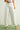 Person wearing white wide-leg jeans on a plain background