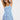 Woman wearing a blue leaf-patterned dress on a white background