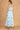 Light blue dress with floral embroidery on a brown background