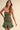 Women’s olive green strapless mini dress with ruched bodice and pleated hem.