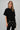 Women's black oversized tunic top featuring a soft knit bodice, polka dot contrast hem, and delicate lace trim.
