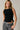 Women's black ribbed sleeveless sweater tank with side button detail and asymmetrical hem.