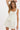 Woman wearing a light-colored dress with a plain background