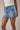 Blue denim skirt worn by a person on a plain background